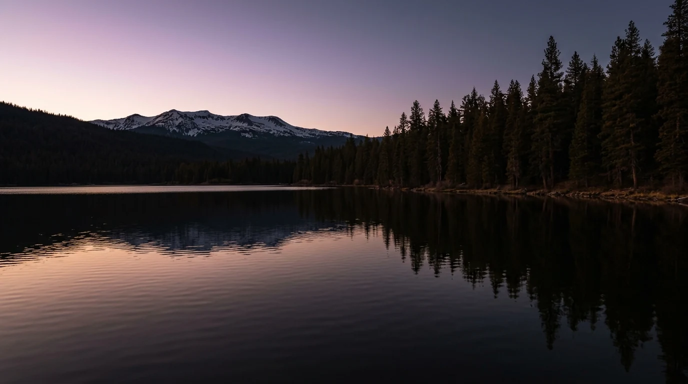 Still lake at dusk ringed by dark pines, on suicide and passing - The Endurant Way